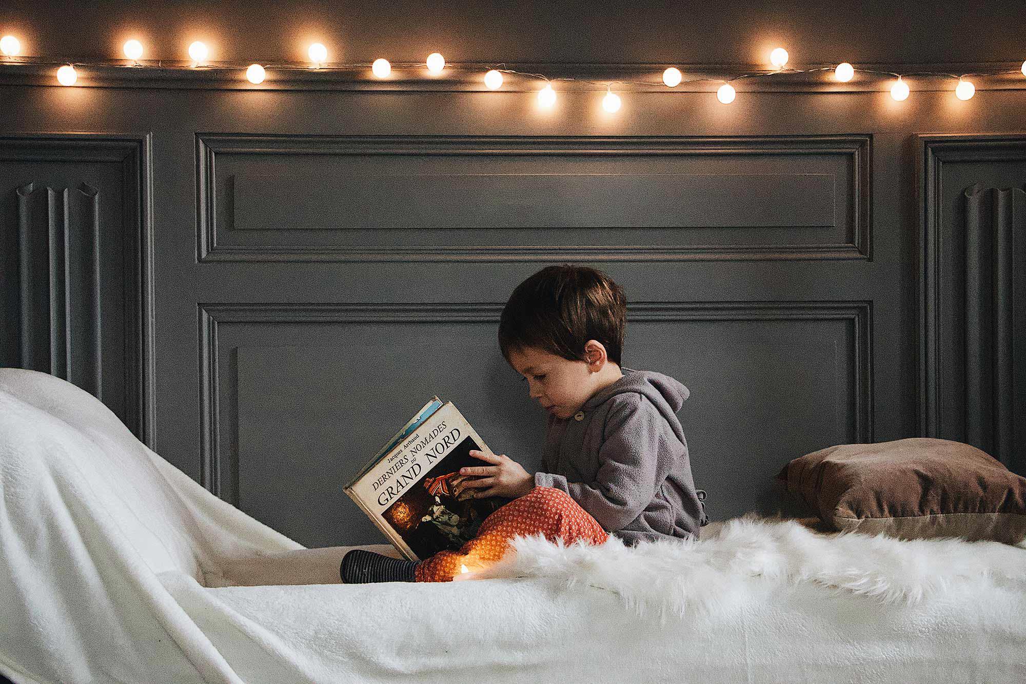 barn som sitter och läser en bok i ett barnrum